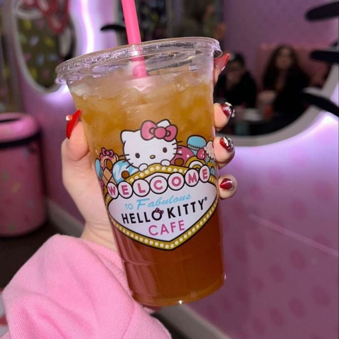 girl holding hello kitty ice coffee latte in a pink bar