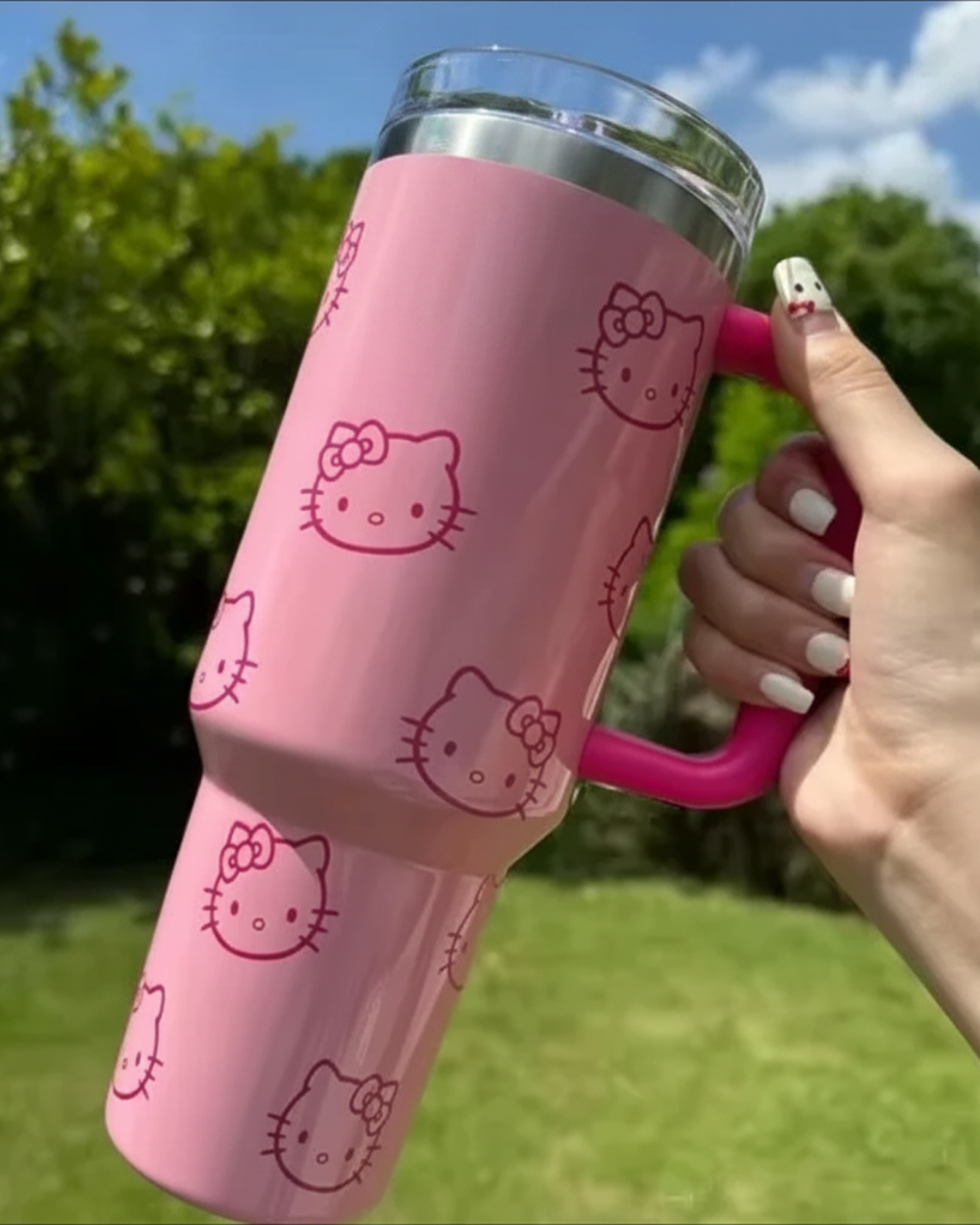 Hello Kitty Pink Tumbler Cup held outdoors as a cute kawaii drink accessory for daily use